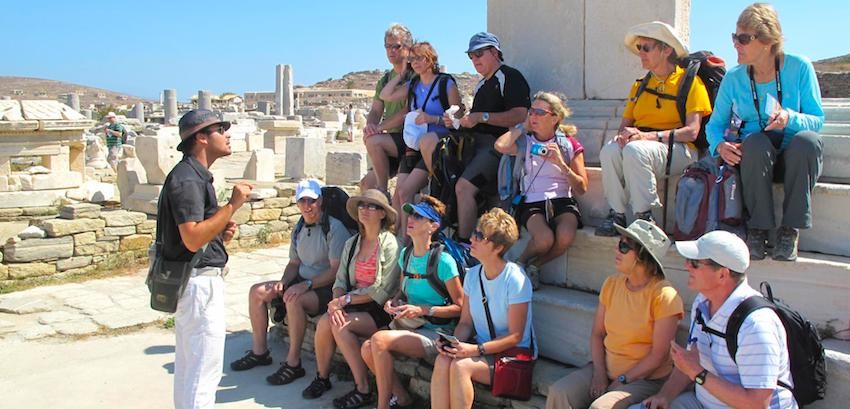 Expert guide speaking with travelers at ancient ruins